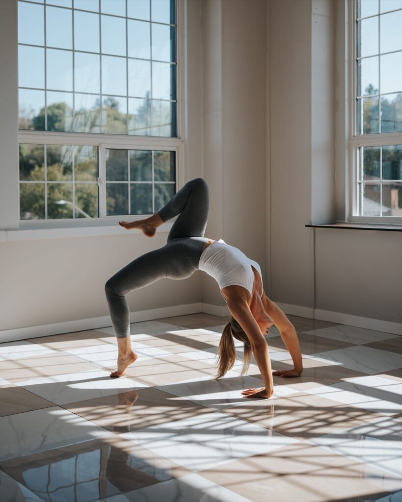 Bridge pose in bright studio with large windows.