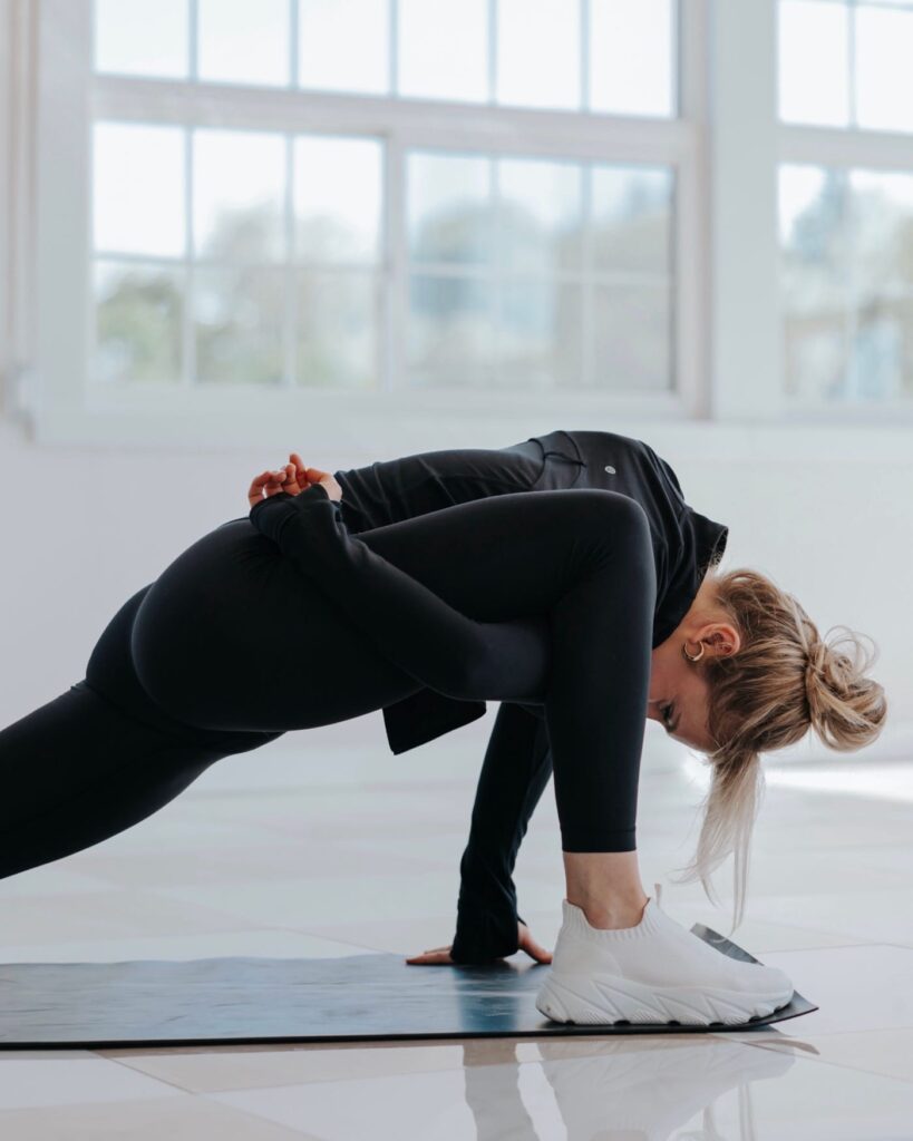 Stretching exercise in a bright gym for flexibility and fitness training.