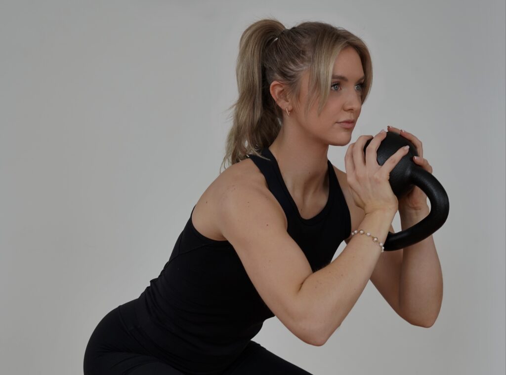 Kettlebell workout woman exercising with kettlebell for strength training.